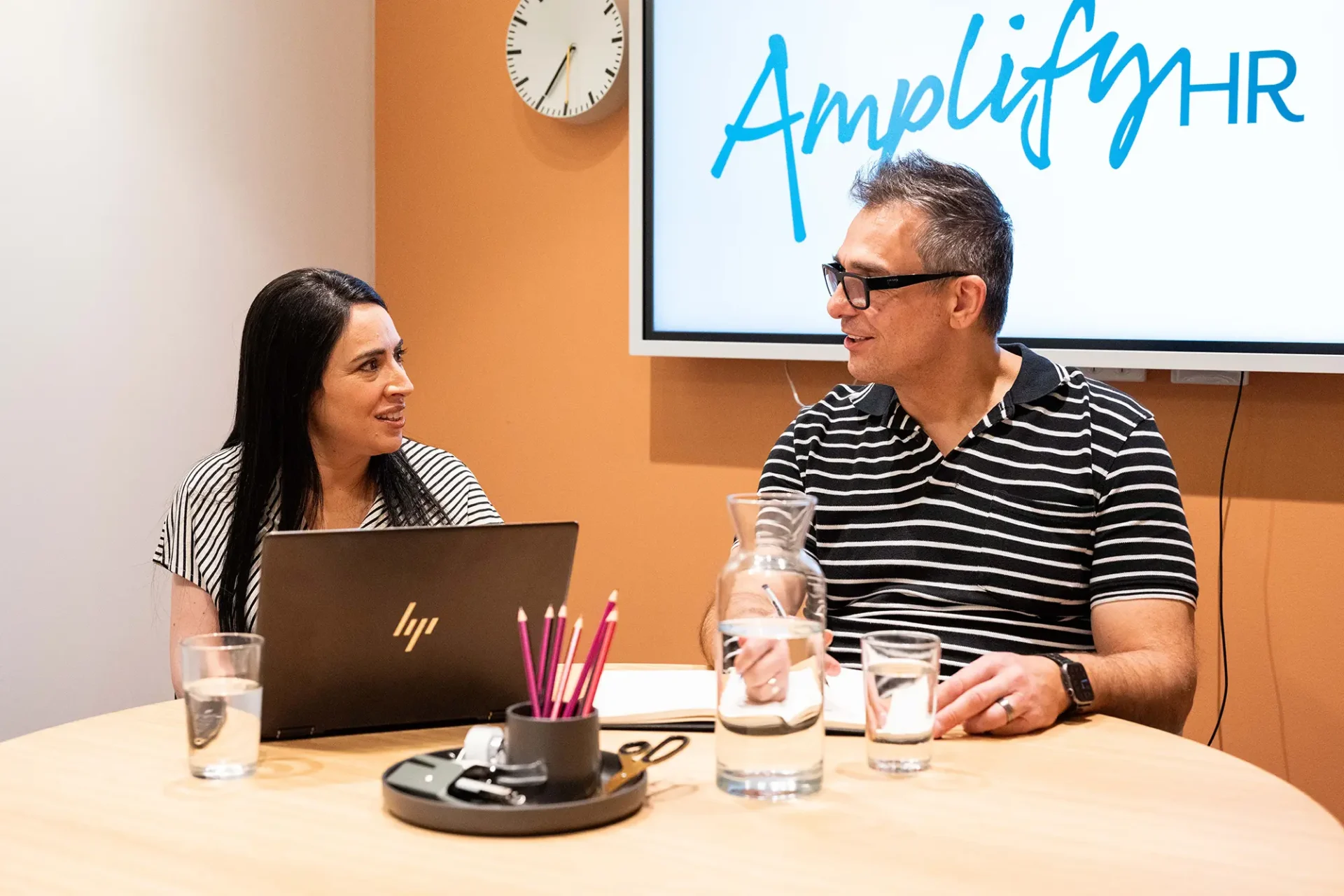 Amplify HR team members meeting in our Sydney office with the company logo